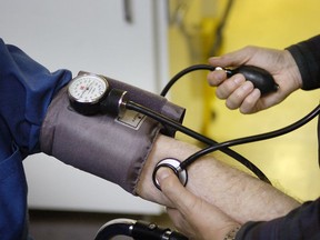 A physician takes a patient's blood pressure: "When patients miss appointments, it exacerbates the wait times to see doctors," Adam Hofmann writes.