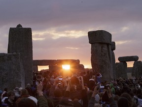 The sun rises as thousands of revellers gathered at the ancient stone circle Stonehenge to celebrate the summer solstice, the longest day of the year, near Salisbury, England, Sunday, June 21, 2015.