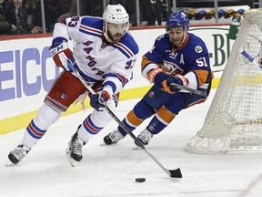 FILE - In this Jan. 14, 2016, file photo, New York Rangers&#039; Keith Yandle (93) works with the puck as New York Islanders&#039; Frans Nielsen (51) follows during an NHL hockey game in New York. Yandle signed with the Florida Panthers early Thursday, June 23, three days after the team acquired the high-scoring defenseman‚Äôs negotiating rights in a trade with the Rangers. The Panthers sent a sixth-round pick in the draft this week to the Rangers on Monday, and now owes New York a fourth-round pick next