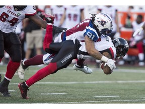 Ottawa Redblacks running back Travon Van is tackled by Montreal Alouettes defensive tackle Alan-Michael Cash (91)during second quarter CFL football action, in Montreal on Thursday, June 30, 2016.