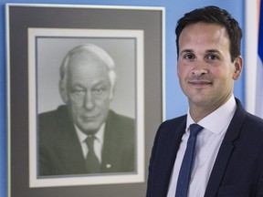 Parti Québécois leadership candidate Alexandre Cloutier walks past a photo of former leader René Lévesque as he deposits the required signatures to validate his candidacy at the party headquarters Tuesday, May 31, 2016 in Montreal.