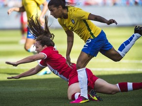 Canada's Allysha Chapman goes to the ground as she battles against Team Brazil's Fabiana during second half international women's soccer friendly action in Toronto Saturday, June 4, 2016.