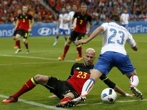 Belgium's Laurent Ciman, left, tackles Italy's Emanuele Giaccherini during the Euro 2016 Group E soccer match between Belgium and Italy at the Grand Stade in Decines-Charpieu, near Lyon, France, Monday, June 13, 2016.