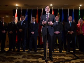 Federal Finance Minister Bill Morneau, centre, is flanked by his provincial and territorial counterparts as he speaks during a news conference after reaching a deal to expand the Canada Pension Plan, in Vancouver, B.C., on Monday June 20, 2016.