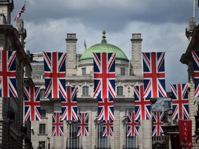Union flags fly as banners across a street in central London on June 28, 2016. EU leaders attempted to rescue the European project and Prime Minister David Cameron sought to calm fears over Britain's vote to leave the bloc as ratings agencies downgraded the country. Britain has been pitched into uncertainty by the June 23 referendum result, with Cameron announcing his resignation, the economy facing a string of shocks and Scotland making a fresh threat to break away. /