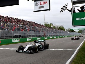 Lewis Hamilton of Great Britain driving the (44) Mercedes AMG Petronas F1 Team Mercedes F1 WO7 Mercedes PU106C Hybrid turbo crosses the line to take the chequered flag and the win during the Canadian Formula One Grand Prix at Circuit Gilles Villeneuve on June 12, 2016 in Montreal, Canada.