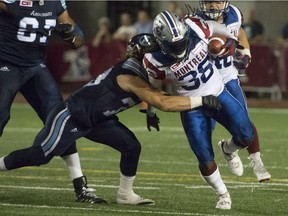 Toronto Argonauts' Curtis Newton grabs Montreal Alouettes ball carrier Dominique Ellis during second half CFL action in Montreal on Friday, June 17, 2016.
