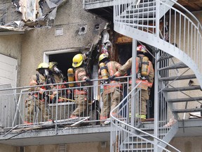 Montreal firefighters fight the remains of a fire at a condo building on Pierre-de-Coubertin Ave. June 22, 2016.