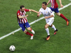 Real Madrid's Cristiano Ronaldo fights for the ball against Atletico's Juanfran Torres during the Champions League final soccer match between Real Madrid and Atletico Madrid at the San Siro stadium in Milan, Italy, Saturday, May 28, 2016.