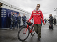 Ferrari F1 driver Sebastian Vettel walks through the paddocks with his bicycle during the open house for the Formula One Canadian Grand Prix at the Circuit Gilles-Villeneuve in Montreal on Thursday, June 9, 2016.