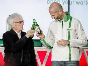 Bernie Ecclestone, Formula One CEO, left, and Gianluca Di Tondo, Heineken senior director of global Heineken brand, right, make a toast after announcing a partnership between Heineken and Formula One Management during the open house of the Canadian Grand Prix at the Circuit Gilles-Villeneuve in Montreal on Thursday, June 9, 2016.