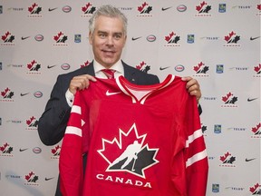 Dominique Ducharme holds up a Team Canada hockey jersey after being named new head coach of the 2016-2017 national junior team following a ceremony in Montreal, Monday, June 6, 2016.