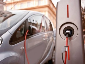 An electric car charging on the street.