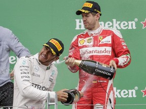 Mercedes Formula One driver Lewis Hamilton, left, celebrates his victory with second place winner Ferrari Formula One driver Sebastian Vettel, right, during the Formula One Canadian Grand Prix at Circuit Gilles-Villeneuve in Montreal on Sunday, June 12, 2016. (Dario Ayala / Montreal Gazette)