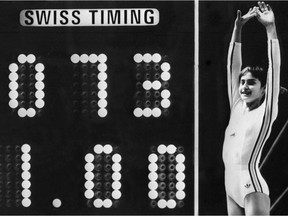 Romanian  gymnast  Nadia Comaneci celebrates on July 18, 1976 as the Montreal Forum scoreboard shows the perfect score of 10 – actually shown as 1.00, as the scoreboard wasn't built to show 10.00 – following her 1976 Montreal Olympic Games routine on the uneven bars.