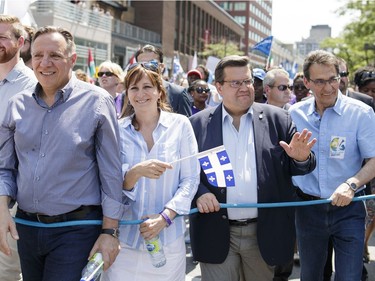 CAQ leader François Legault, left, Montreal Mayor Denis Coderre, second from right, and Montreal city councillor Richard Bergeron, right, take part in the annual Fête Nationale parade for Saint-Jean-Baptiste day on Ste. Catherine Street in downtown Montreal on Friday, June 24, 2016.