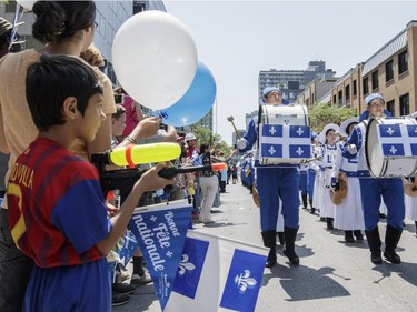 People watch as a marching band takes part in the annual Fete Nationale parade