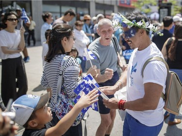 A volunteer hands out Quebec flags