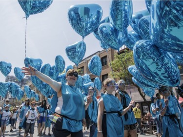 People hold ballots as they take part in the annual Fête Nationale parade for Saint-Jean-Baptiste day on Ste. Catherine Street in downtown Montreal