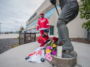 Jace Ryder and his father, George, visit a statue of Gordie Howe outside of the Sasktel Centre in Saskatoon, Friday, June 10, 2016. Howe passed away at the age of 88.