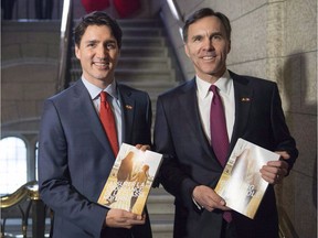 Prime Minister Justin Trudeau, left, and Minister of Finance Bill Morneau show off this year's budget on March 22, 2016, in Ottawa.