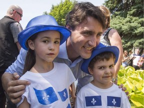 Prime Minister Justin Trudeau poses for photos with children during Fete Nationale festivities on Friday, June 24, 2016 in Ste. Therese, Que.