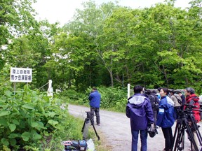 Media members gather near a military drill area in Shikabe town, on the northernmost main island of Hokkaido Friday, June 3, 2016. The 7-year-old Japanese boy who went missing nearly a week ago after his parents left him in a forest as punishment was found unharmed Friday morning by a soldier in the military drill area, police said.