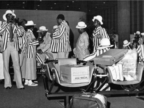 Members of the Nigerian Olympic team prepare for their journey home at Montreal's Mirabel Airport July 16, 1976 after it was announced they would boycott the Olympic Games.  The boycott came after the IOC refused to expel New Zealand from competition.