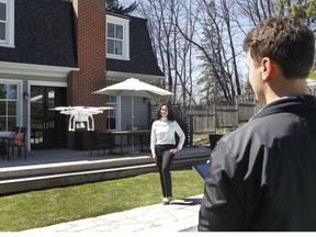 Liam Callou controls the drone equipped with a camera to shoot a video of real estate agent Shereen Quraeshi outside home in Pointe-Claire. (Marie-France Coallier/MONTREAL GAZETTE)