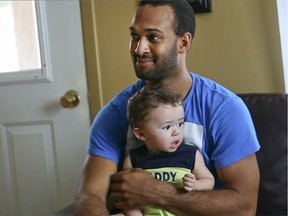 David Courage is photographed with his son, Mael Angel at home in 2013, a year after being shot at the Metropolis.