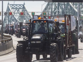 A convoy of tractors crosses the Jacques-Cartier bridge on Wednesday June 1, 2016. The group of farmers are travelling by tractor to Ottawa to protest imports of American milk.