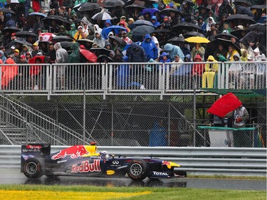 Red Bull Racing Formula One driver Sebastian Vettel drives past the red flag as he approaches turn 10 as he competes in the 2011 Canadian Grand Prix. Due to torrential rains the race is temporarily stopped midway and ends up being the longest and most chaotic F1 race of all time.