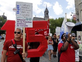 Striking Old Port of Montreal workers march down Place Jacques-Cartier in Montreal on Wednesday, June 15, 2016.