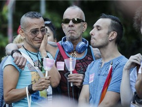 Jade Perrichon, left and Sophie Juillard comfort each other after taking part in a vigil for the Orlando Florida shooting victims in Parc de l'Espoir in Montreal on Sunday June 12, 2016.