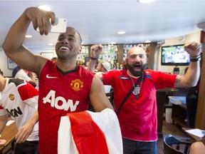Adri Powell, left, celebrates with Mike Marounian after England scores the winning goal against Wales. English supporters were watching the Euro 2016 match at the Burgundy Lion pub in Little Burgudy on Thursday, June 16, 2016.
