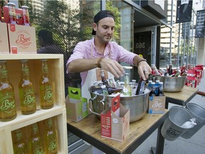 Olivier Dionne prepares bottles of Bec Soda for passersby to taste in front of Fou d'Ici supermarket on de Maisonneuve Blvd. in downtown Montreal on Friday June 17, 2016.