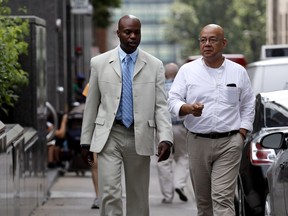 Alrick Bowen, left, walks with Centre for Research Action on Race Relations, CRARR, executive director Fo Niemi in Montreal on Monday June 20, 2016.