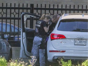 Montreal police inspect a car, June 21, 2016, in which a man was fatally shot in Pointe aux Trembles.