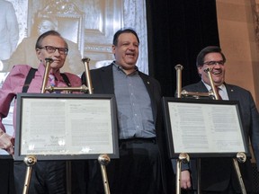 Left to right: Famed television broadcaster Larry King, collector Mykalai Kontilai, and Montreal Mayor Denis Coderre pose for photographs at the unveiling of the original baseball contracts between the Montreal Royals and Brooklyn Dodgers and baseball legend Jackie Robinson of during a press conference at Montreal City Hall on Wednesday, June 22, 2016.