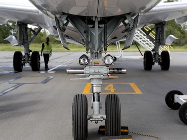 A technician checks the landing gear of a CS 100 at Bombardier in Montreal on Wednesday June 29, 2016.