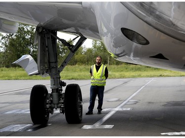A technician stands next to the landing gear before a media flight in the first CS 100 to be delivered by Bombardier in Montreal on Wednesday June 29, 2016.