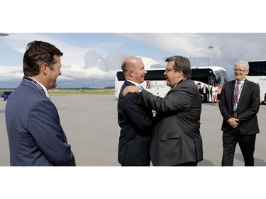 Pierre Beaudoin, left, executive chairman of the board of Bombardier and Marc Garneau, right, MP for Westmount-Ville Marie watch as Alain Bellemare, CEO of Bombardier greets Denis Coderre, mayor of Montreal, as they prepare to board a CS 100 series jet as Bombardier delivers the new plane to Swiss Air in Montreal on Wednesday June 29, 2016.
