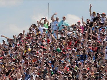 Fans look up at a jet doing a flyby at the start of the 2014 Canadian Grand Prix. Of all the races on the Grand Prix circuit, Montreal’s is among the most-watched, helped in large part by the early-afternoon start — prime time in Europe, where the fan base remains strongest.