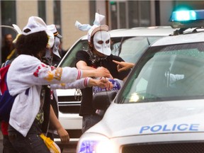 Masked protesters taunt police during a protest march during Quebec's Maple Spring in 2012.
