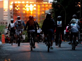 The last rays of sun hit Montreal buildings as cyclist take part in the Tour la Nuit, the night edition of the Tour de L'lle in Montreal on Friday May 30, 2014.