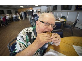 MONTREAL, QUE.: SEPTEMBER 11, 2014 --  David Newton of Beaconsfield enjoys a burger during a BBQ lunch at Branch 91 of the Royal Canadian Legion in Ste-Anne-de-Bellevue on Thursday, September   (Peter McCabe / THE GAZETTE) ORG XMIT: 50911