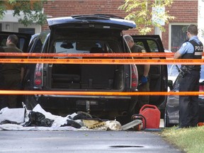 Montreal and Surete Quebec officers investigate the car belonging to the suspect in Tuesday night's Metropolis shooting, in Montreal, Sept. 5, 2012.