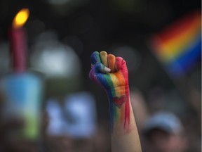 A fist is raised at a Los Angeles vigil for the Orlando shooting. The murders reveal the fight for acceptance is nowhere near being over, even as gains are made.
