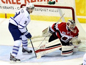 Michael McLeod #9 of the Mississauga Steelheads waits for rebound in front of Leo Lazarev #37 of the Ottawa 67's during OHL game action on December 19, 2014 at the Hershey Centre in Mississauga, Ontario, Canada.