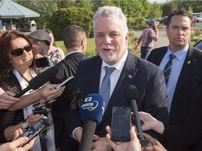 Quebec Premier Philippe Couillard responds to reporters' questions as he arrives at a special party caucus meeting, Monday, May 30, 2016 in Quebec City.